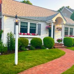 White house with beautiful green lawn and brick pathway